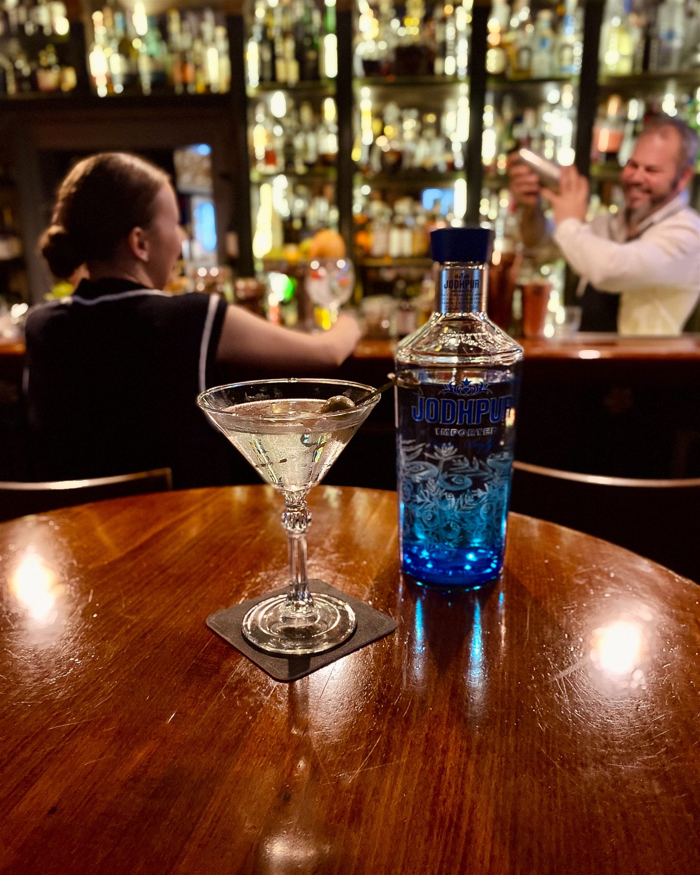 Koktejl a lahev Jodhpur Gin v baru Apotheka